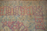 Decorative distressed Kerman rug border with cypress trees and floral bouquets in soft pastels.
