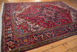Angled view of the vintage Mehrivan carpet's corner, detailing the turtle border and plush cherry red pile.