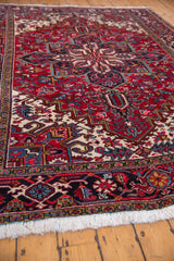 Angled view of the traditional Persian Mehrivan rug's plush wool pile in red, navy, and ivory.