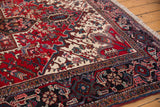 Angled view of the hand-knotted pile and geometric turtle border on a vintage Mehrivan carpet.