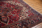 Side view of the vintage Mehrivan carpet's plush pile, fringe, and intricate navy turtle border.