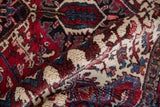 Plush, full pile of a vintage Mehrivan carpet showing geometric details in red, navy blue, and ivory.