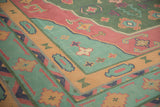 Geometric primitive motifs in turquoise green, raspberry red, and sand on a vintage Dhurrie.