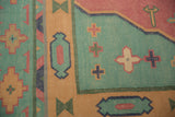 Flat-woven vintage dhurrie carpet detail, showing geometric cross motifs in turquoise green.