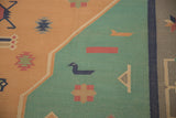 Detail of vintage Dhurrie rug with playful duck motif on pale turquoise and dusty gold.