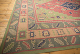 Abstract geometric patterns on vintage Dhurrie carpet in pale raspberry, navy, and sage green.