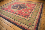 Vintage Dhurrie corner showing geometric star border in sage green, red, navy, with fringe.
