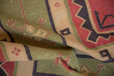 Vintage Stone Wash Dhurrie rug's geometric pattern with sage green, brick red, and navy folds.
