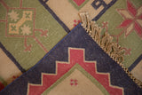 Folded corner of vintage dhurrie, showing navy flat weave, original selvage, and fringe.