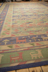 Vintage Dhurrie rug detail with stylized animals, trees in seafoam green, raspberry, and ivory.