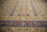 Dark blue band with stylized animal motifs and geometric patterns on the vintage Dhurrie carpet.