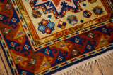 Vintage Siberian Kazak rug corner with saffron yellow geometric patterns, full pile, intact selvage, and fringe.