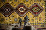 One geometric diamond medallion of a Siberian Caucasian rug with dusty gold, rust, and silver.