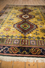 Close-up of the Siberian Caucasian carpet's dark blue border with curvilinear rust motifs and ivory fringe.