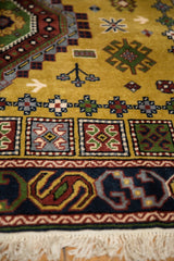 Vintage Siberian Caucasian carpet border, dark blue with rust, green, gold geometric motifs, and cream fringe.