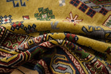 Folded vintage Siberian Caucasian carpet, plush dusty gold pile, geometric patterns.