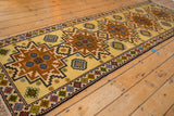 Vintage Kazak runner corner, saffron yellow field, copper geometric medallion, and fringe.