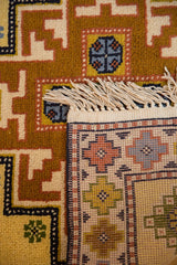 Vintage hand-knotted Kazak runner: saffron geometric pile, foundation weave, and fringe.