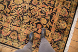 Detailed gold, red, and sage palmettes with vinery on a dark Arts and Crafts rug.