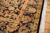 Close-up of Indian Arts and Crafts rug border with gold scrolled vinery, red palmettes, and fringe.