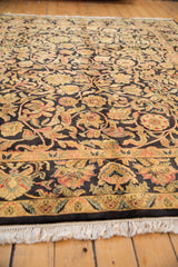 Intact ivory fringe and intricate scrolled vinery border detail on the vintage carpet.