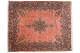 Vintage Kerman carpet with a floral medallion and intricate millefleur border on a dusty rose field.