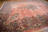 Sprawling dusty rose field of a vintage Kerman carpet, framed by an intricate millefleur border.