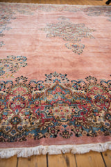 Low angle view of a vintage Kerman's plush pile and detailed millefleur border in blue and red.