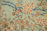 Plush pile detail of seafoam green vintage Japanese Art Deco rug with beige, blush, and indigo floral vines.