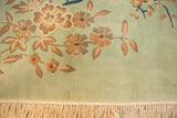 Plush seafoam green pile of a vintage Japanese Art Deco carpet with ornate floral vines and ivory fringe.
