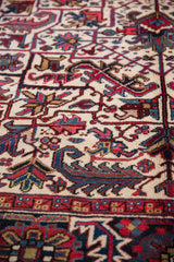 Plush hand-knotted pile showing geometric floral details in navy, red, and sky blue.
