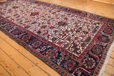 Full view of a vintage Mehrivan runner showing its allover floral palmettes and dark navy border.
