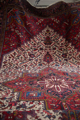 Draped perspective of a vintage Mehrivan carpet's intricate lattice and sapphire blue medallion detail.