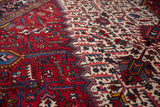 Angled detail of a vintage Mehrivan carpet's serrated leaf lattice in sapphire blue, wine red, and ivory.