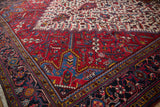 Corner detail of a vintage Mehrivan showing serrated leaf motifs against a rich red and blue design.