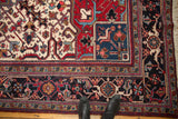 Corner detail of vintage Mehrivan carpet, showing red, navy, and ivory geometric floral vinery.