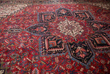Angled view of Vintage Mehrivan rug, Heriz-style geometric medallion on red field.