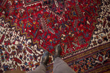 View of the plush cherry red pile and geometric floral motifs on a vintage Persian Mehrivan rug.