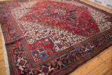 A vintage Mehrivan square carpet showing its plush pile, red medallion, and navy samovar turtle border.