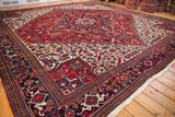 Angled view of the vintage Mehrivan rug's samovar turtle border and red medallion.