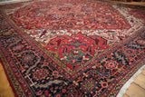 Rich gem-tone colors and intricate geometric patterns on the corner of a vintage Heriz carpet.