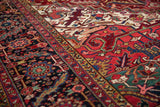 Fine weave detail of a vintage Heriz carpet's serrated leaf border in gem-tone shades.