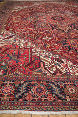 Low angle view showing the full, dense pile and rich gem-tone colors of a vintage Heriz carpet.