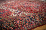Low angle view of a vintage Heriz carpet showing its plush wool pile and intricate gem-tone details.