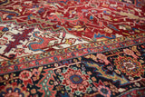 Serrated leaf border and plush, fine weave of a vintage Heriz carpet in rich gem-tone shades.