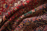 Densely ornamented patterns and full wool pile of a vintage Heriz carpet in gem-like tones.