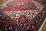 Angled view of the vintage Mehrivan carpet's plush pile and red geometric starburst medallion.