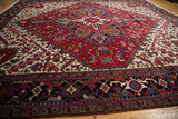 Expansive low-angle view of a vintage Mehrivan carpet with its bold geometric border and red medallion.