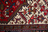Crisp hand-knotted detail of serrated leaves and buds in red, navy, and gold.