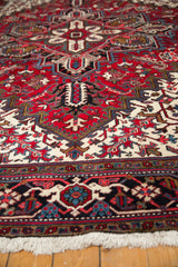 Angled view of the full pile, geometric border, and ivory fringe on a vintage Mehrivan carpet.